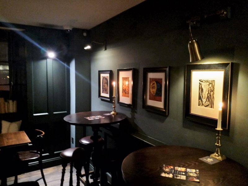 Circular pub tables and prints on wall. (Pub). Published on 09-11-2019
