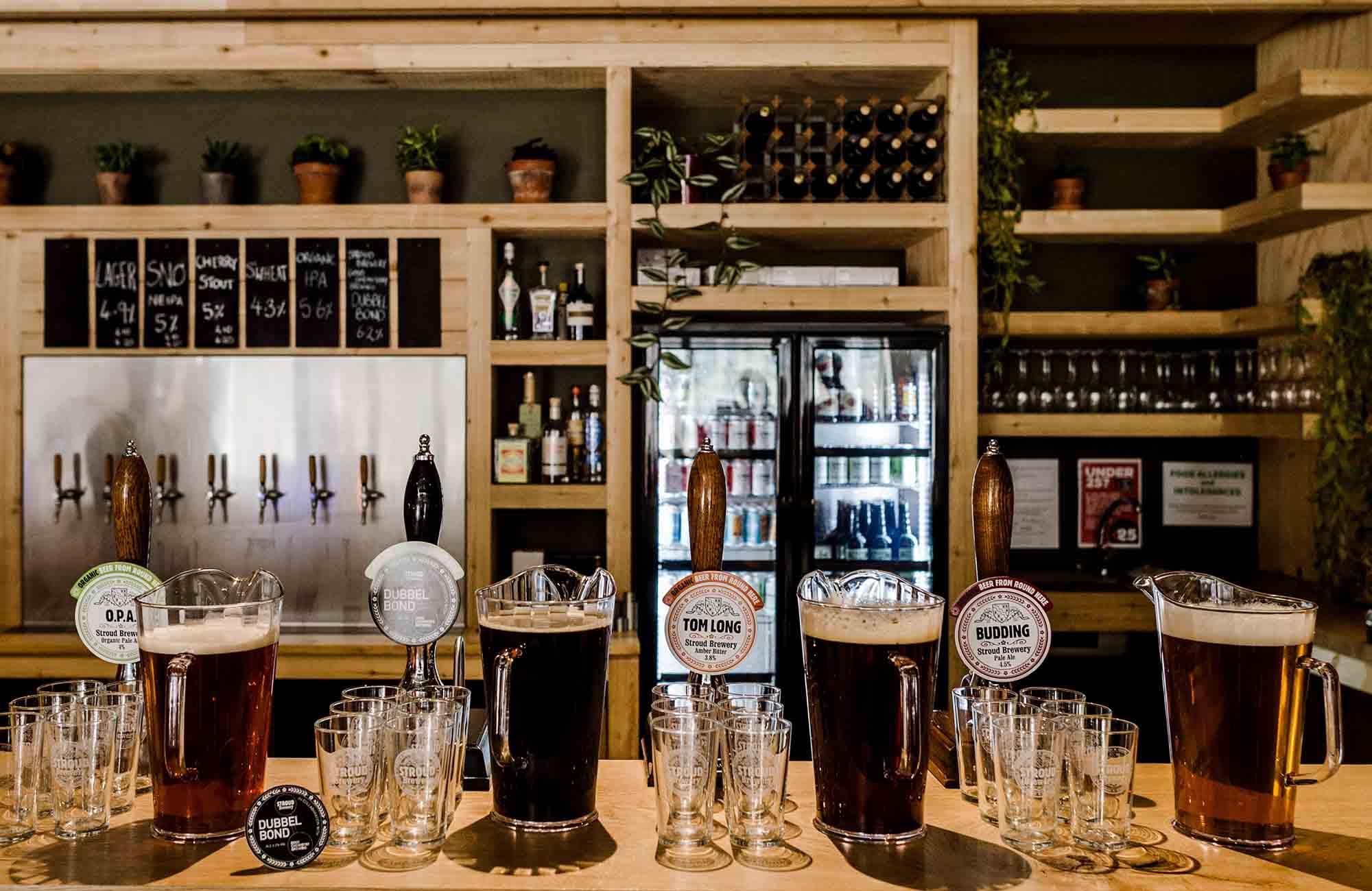 Stroud Brewery bar with handpumps pitchers of beer and empty gla. (Brewery, Bar). Published on 21-03-2020