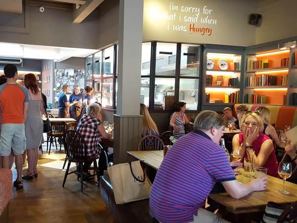 A view of the open kitchen and some seating. (Pub, Customers). Published on 08-07-2017