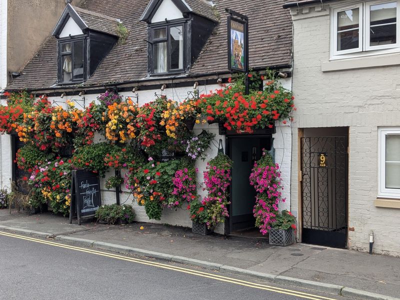 Behind the floral display there is a pub. (Pub, External, Sign, Key). Published on 25-09-2026